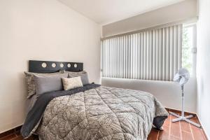 um quarto com uma cama e uma janela em Espaciosa Casa Moderna c/ Patio Privado em Aguascalientes