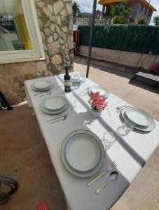 una mesa con platos y copas y una botella de vino en Estudio con terraza en Guarnizo, en El Astillero