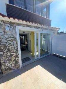 a sliding glass door on a building with a stone wall at Estudio con terraza en Guarnizo in El Astillero