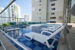 a swimming pool with lounge chairs in a building at Apartamento Unik Cartagena Edificio Poseidón in Cartagena de Indias