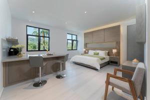 Hotel Cordelia Resort & Spa في لوريتو: غرفة نوم مع سرير ومكتب ومكتب