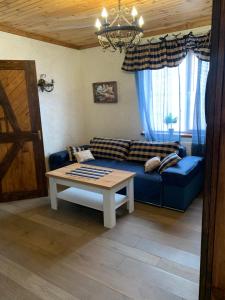 uma sala de estar com um sofá azul e uma mesa em RELAX COMPLEX HOTEL em Boryspil