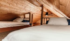 a bedroom with two beds in a wooden cabin at Riverside Resort in Whistler