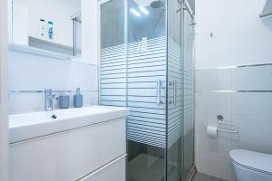 a white bathroom with a sink and a shower at Il Mattone Rosso/zona Politecnico e BorgoSan Paolo in Turin +14 photos