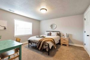 a bedroom with a bed and a table and a window at Sleepy Ridge Apt in Vineyard/Orem (Sleeps 6) in Orem