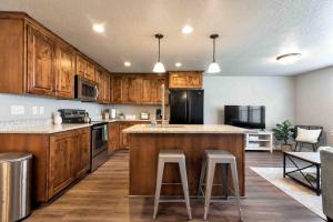 a kitchen with wooden cabinets and a island with bar stools at Sleepy Ridge Apt in Vineyard/Orem (Sleeps 6) in Orem