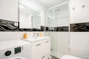 een witte badkamer met douche en wastafel bij Sunset in Armação de Pêra +60 foto's