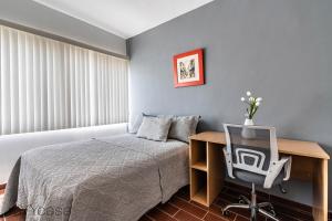 um quarto com uma cama e uma secretária com um computador em Cómoda Casa c/ Patio Privado en Aguascalientes em Aguascalientes