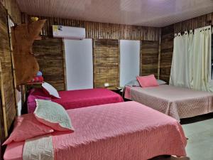 Cette chambre comprend 2 lits avec des draps roses. dans l'établissement Tatacoa Star Eco Hotel, à Villavieja