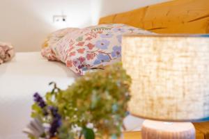 Una cama con una almohada y un jarrón de flores sobre una mesa en Naturliebe Samerberg, en Samerberg