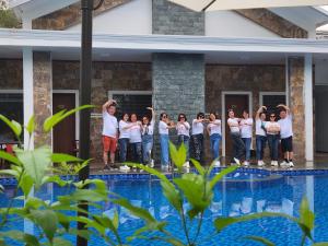 a group of people standing next to a swimming pool at Châu Sơn Garden Resort in Ninh Binh