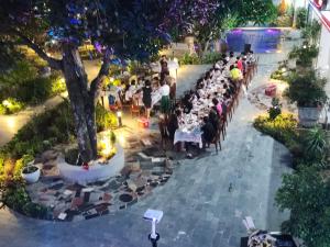 un grupo de personas sentadas en mesas en un jardín en Châu Sơn Garden Resort, en Ninh Binh