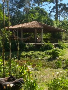 a gazebo with a hammock in a garden at Sitio-Estalagem Purioca in Cunha