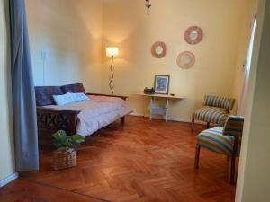a bedroom with a bed and a table and a chair at Casa Porto in Mendoza
