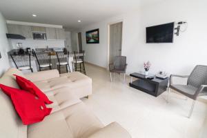卡塔赫纳Apartamento Unik Cartagena Edificio Faro Tequendama的客厅配有带红色枕头的白色沙发
