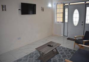 a living room with a table and a tv on a wall at Villa Cherry in Gros Islet