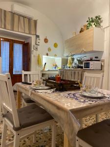 a kitchen with a large wooden table with chairs at TumHouse (la capanna di zio Tom) in Ceglie Messapica