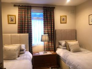 1 dormitorio con 2 camas y ventana en Helena Host Family, en Londres