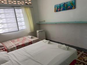 um quarto com 2 camas e uma janela em Costa de Vikingos em Tolú
