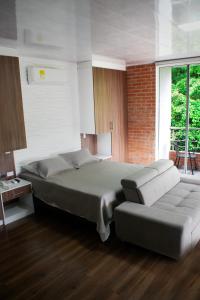 El Pedregal的住宿－Cucaña Hotel，一间卧室配有一张大床和一张沙发