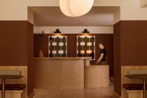 a woman standing at a bar in a restaurant at Sonder The Fitz in Saint Paul