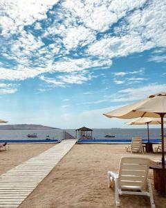 una playa con sillas y sombrillas en la playa en Condominio Nautico Paracas, en Pisco