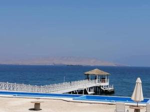 Un muelle en medio del océano con una sombrilla en Condominio Nautico Paracas, en Pisco 13 fotos más
