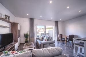 sala de estar con sofá, TV y mesa en Apartment Paradise Baleal with AC, en Baleal