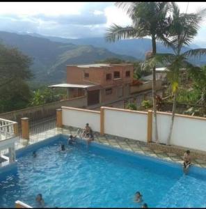 a large swimming pool with people in the water at HOTEL ANAHÍ in Chulumani