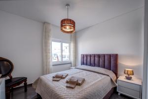 a bedroom with a bed with two towels on it at Beach & Surf Lovers Apartment with AC - Baleal in Baleal +14 photos