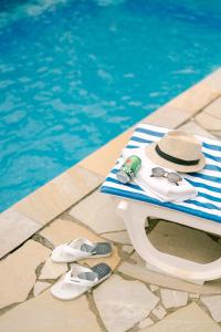 una mesa con sombrero y gafas de sol junto a una piscina en Hotel Kiribati Maresias, en Maresias