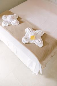 two towels sitting on top of a bed at Hotel Kiribati Maresias in Maresias