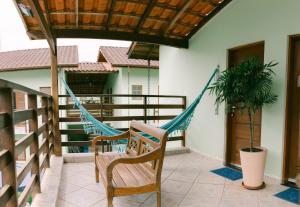 a hammock on the balcony of a house at Hotel Kiribati Maresias in Maresias