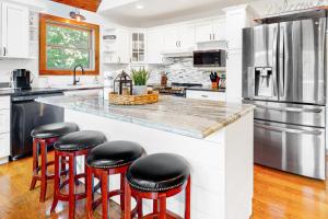 a kitchen with white cabinets and a counter with stools at Firefly Ridge in Townsend