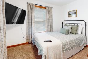 a bedroom with a bed and a flat screen tv at Firefly Ridge in Townsend