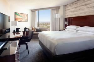 a hotel room with a large bed and a living room at Marriott Albuquerque in Albuquerque