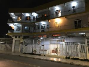 un bâtiment avec une clôture devant lui la nuit dans l'établissement Hotel Belo Jardim, à Hortolândia