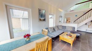ein Wohnzimmer mit einem Sofa und einem Tisch in der Unterkunft Feriendorf Südstrand Haus 13 in Pelzerhaken