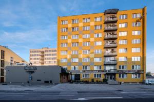 een groot geel gebouw met balkons in een straat bij Hotel U Nádraží in České Budějovice