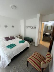 a bedroom with a bed and a bathroom with a sink at El canto de los pajaros in Villa Carlos Paz