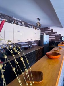 cocina con armarios blancos y mesa de madera en Casa Rarăului, en Câmpulung Moldovenesc