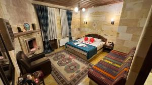 ウルギュップにあるAkuzun Stone Hotelのベッドと暖炉付きの広い客室です。