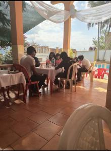 eine Gruppe von Menschen, die an einem Tisch auf einer Terrasse sitzen in der Unterkunft HOTEL ANAHÍ in Chulumani