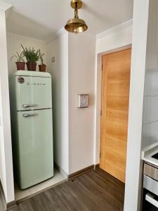 een groene koelkast in een keuken naast een deur bij Acogedor espacio de descanso in Antofagasta