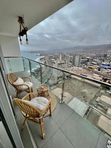een balkon met stoelen en uitzicht op de stad bij Acogedor espacio de descanso in Antofagasta