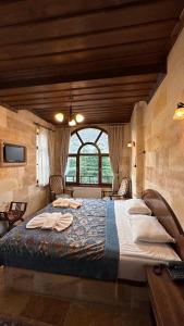 duże łóżko w pokoju z dużym oknem w obiekcie Akuzun Stone Hotel w mieście Ürgüp