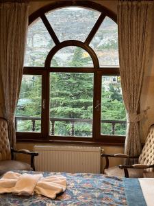 a bed in a room with a large window at Akuzun Stone Hotel in Ürgüp