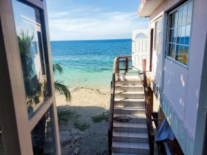 eine Treppe, die von einem Haus zum Strand führt in der Unterkunft Evelin's On The Beach in Montego Bay