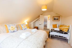 a bedroom with a large white bed and a chair at Westholme Lodge in Minehead