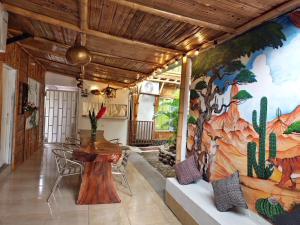 uma sala de jantar com um mural de cactos na parede em Tatacoa Star Eco Hotel em Villavieja